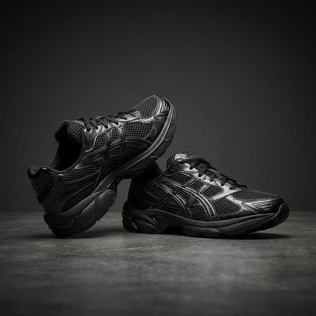 ASICS Gel-1130 Black Graphite Grey pair displayed stacked on dark grey studio background showing full shoe silhouette