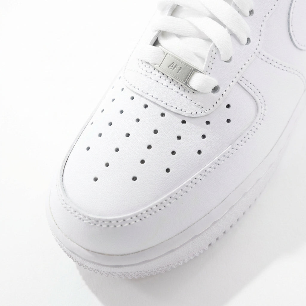 Nike Air Force 1 '07 Triple White toe box close-up showing perforations and AF1 metal lace tag