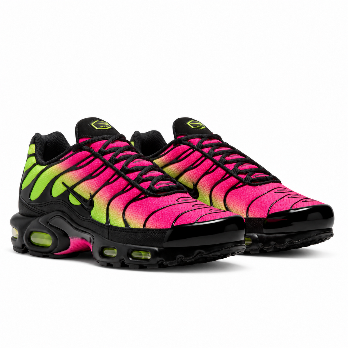 A pair of Nike Air Max Plus TN Hyper Pink Volt trainers featuring a vivid pink and neon green gradient mesh upper, black TPU wave overlays and visible Volt Tuned Air cushioning on a clean white background.
