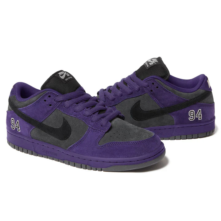 Supreme x Nike SB Dunk Low Ink Black pair front three-quarter view showing purple suede, black Swoosh and Supreme midsole