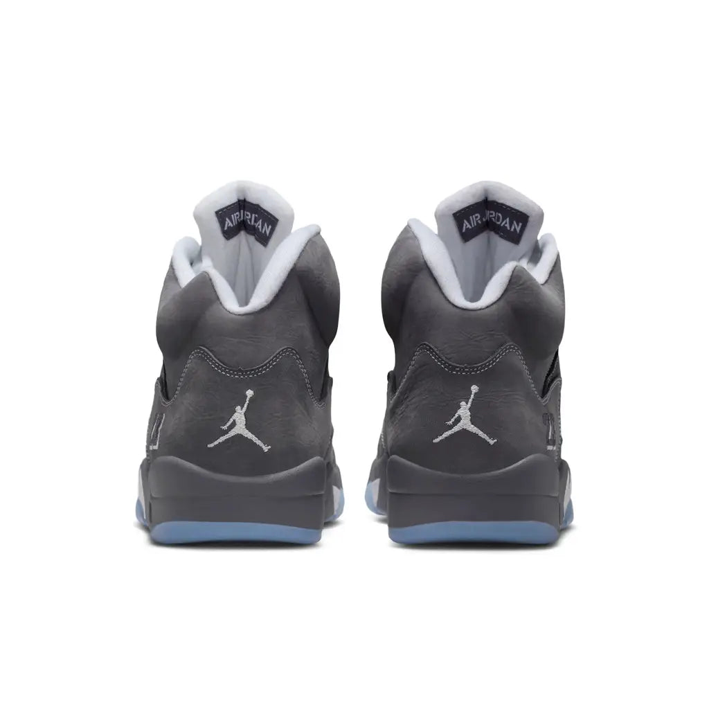 Back heel view of the Air Jordan 5 Wolf Grey retro shoe, displaying the embroidered Jumpman logo, buttery grey nubuck leather, and chunky midsole.