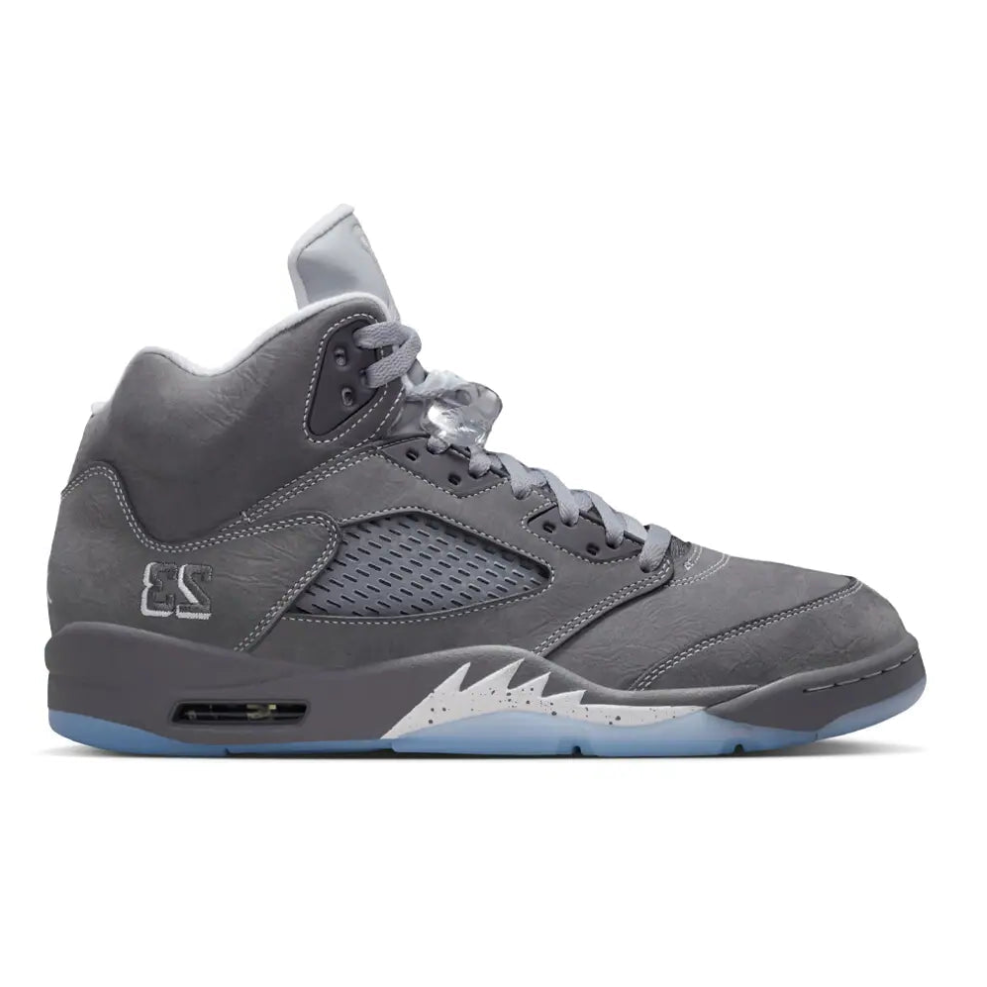 Side profile of the Air Jordan 5 Wolf Grey, highlighting the white contrast stitching, embroidered 23, speckled shark teeth, and icy translucent outsole.