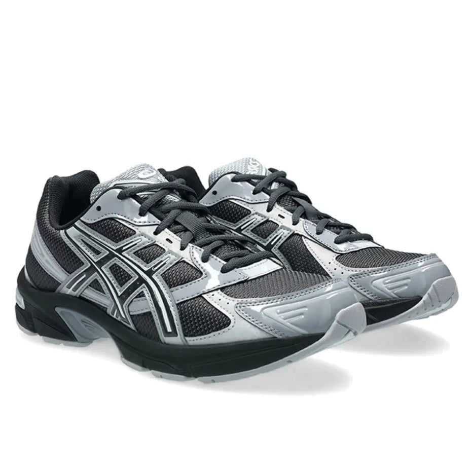 A pair of ASICS GEL-1130 Graphite Grey Gravel trainers featuring dark graphite mesh, glossy grey overlays, signature ASICS stripes and a cushioned GEL sole on a clean white background.