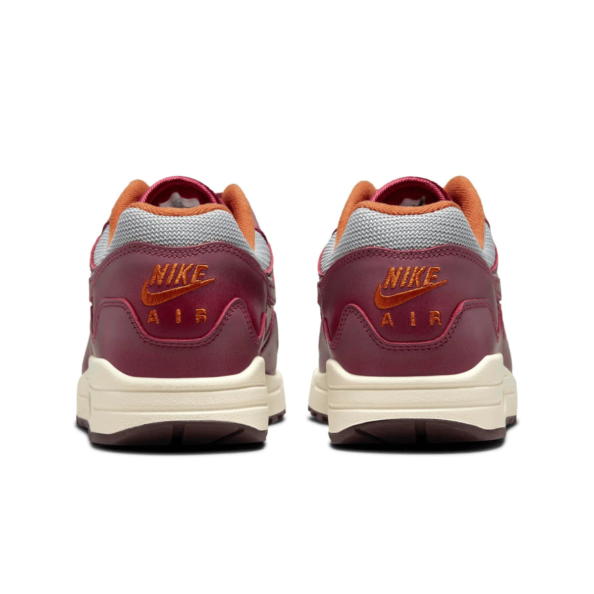 A rear view of the Patta x Nike Air Max 1 Night Maroon showing the maroon heel panel, orange Nike Air branding and Sail midsole.