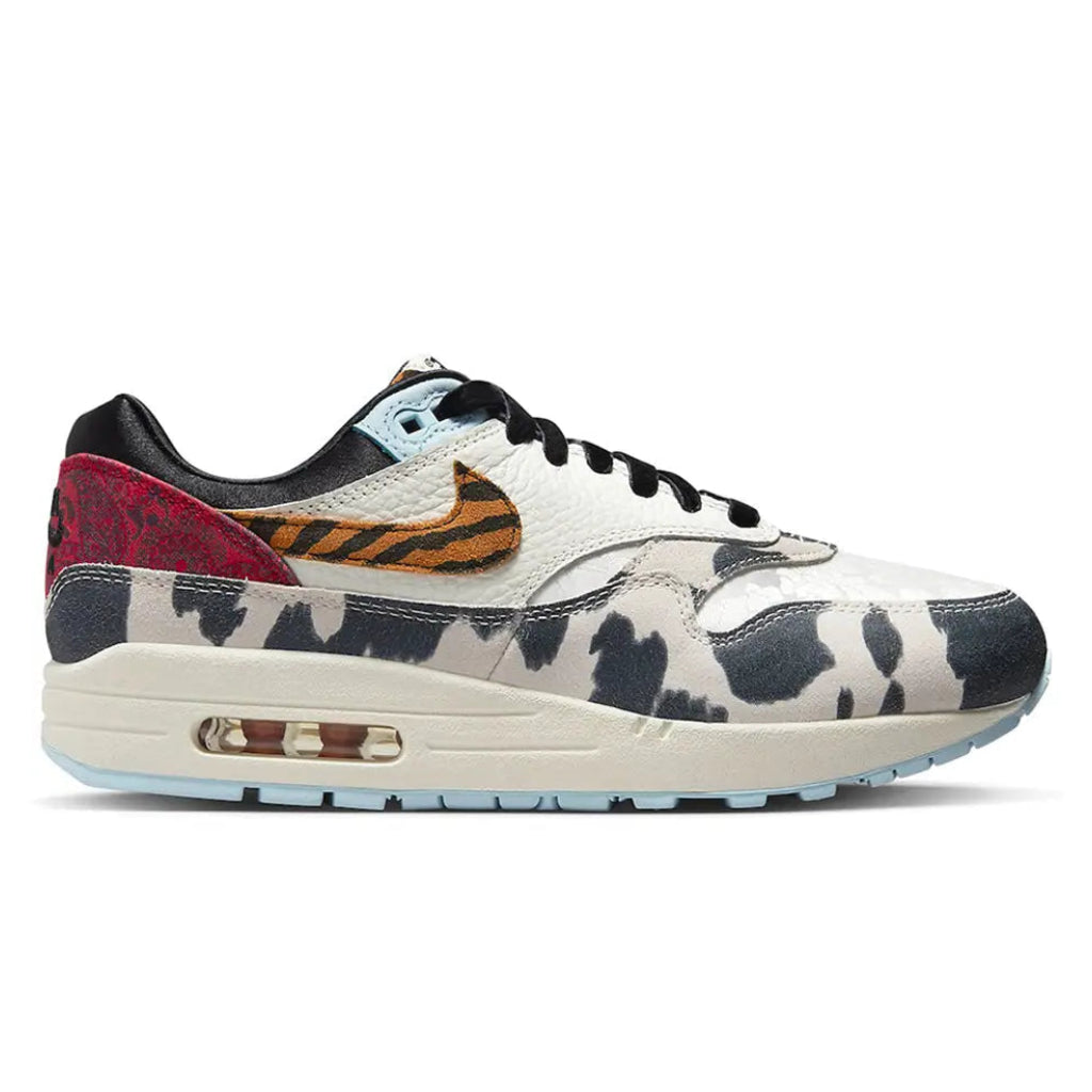 A side view of the Nike Air Max 1 Wild Animal showing the cow-print mudguard, tiger-striped Nike Swoosh and mixed patterned upper.
