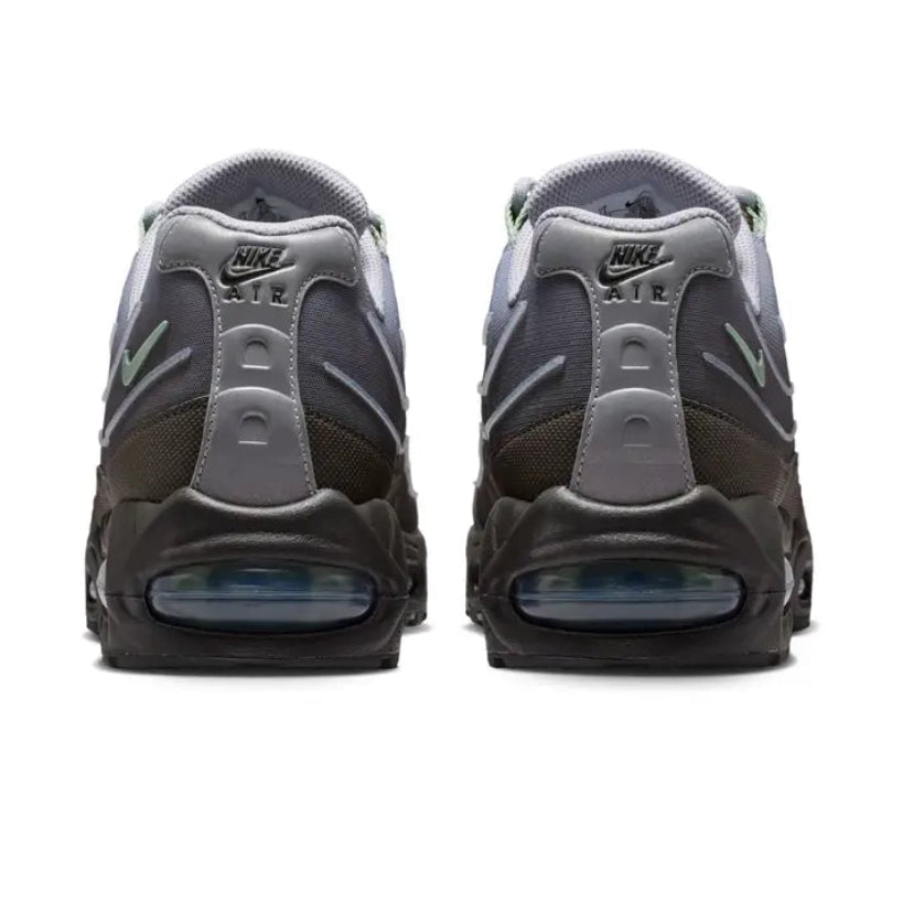 A rear view of the Nike Air Max 95 Medium Ash trainers, showing the structured heel, tonal grey and metallic detailing and visible Air cushioning.