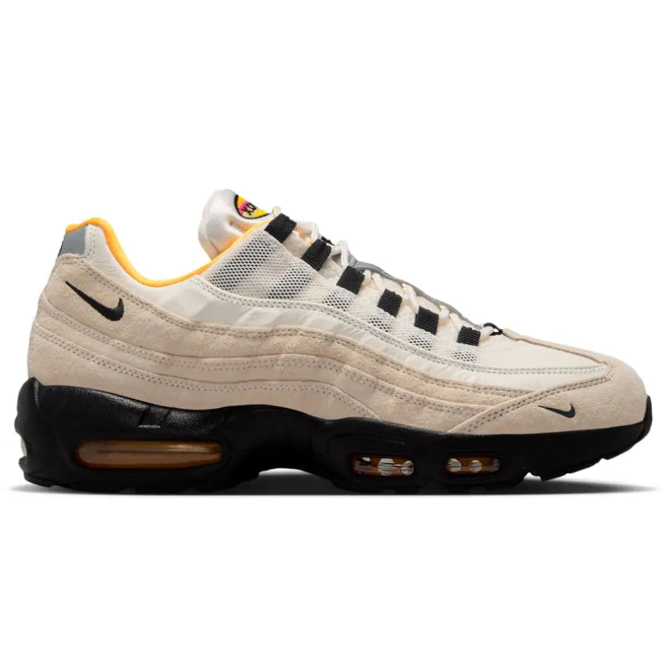 A side view of the Nike SB Air Max 95 World Cup Pack Sail trainer, showing the Sail layered upper, black accents, orange detailing, Nike Swoosh and visible Air cushioning.