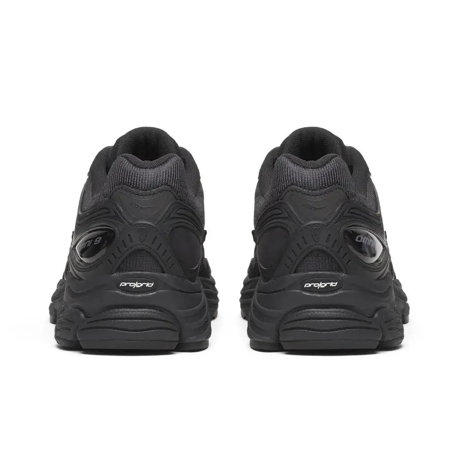 A rear view of the Saucony ProGrid Omni 9 Armour Black trainers, showing the structured black heel, tonal detailing and sculpted cushioned sole on a clean white background.