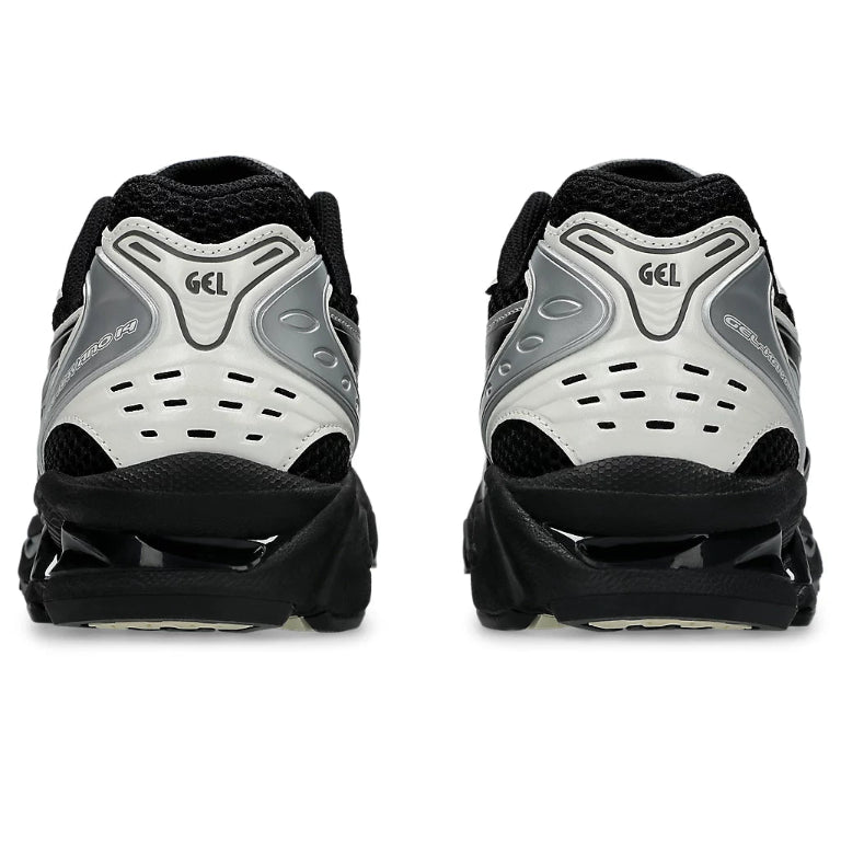 A rear view of the ASICS GEL-KAYANO 14 Black Cream trainers, showing the structured heel, contrasting black and cream detailing and cushioned sole unit on a clean white background.