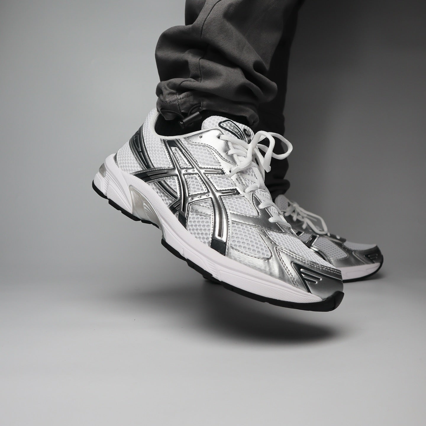 ASICS GEL-1130 White Silver on foot showing lateral side with silver Tiger Stripes and white mesh upper