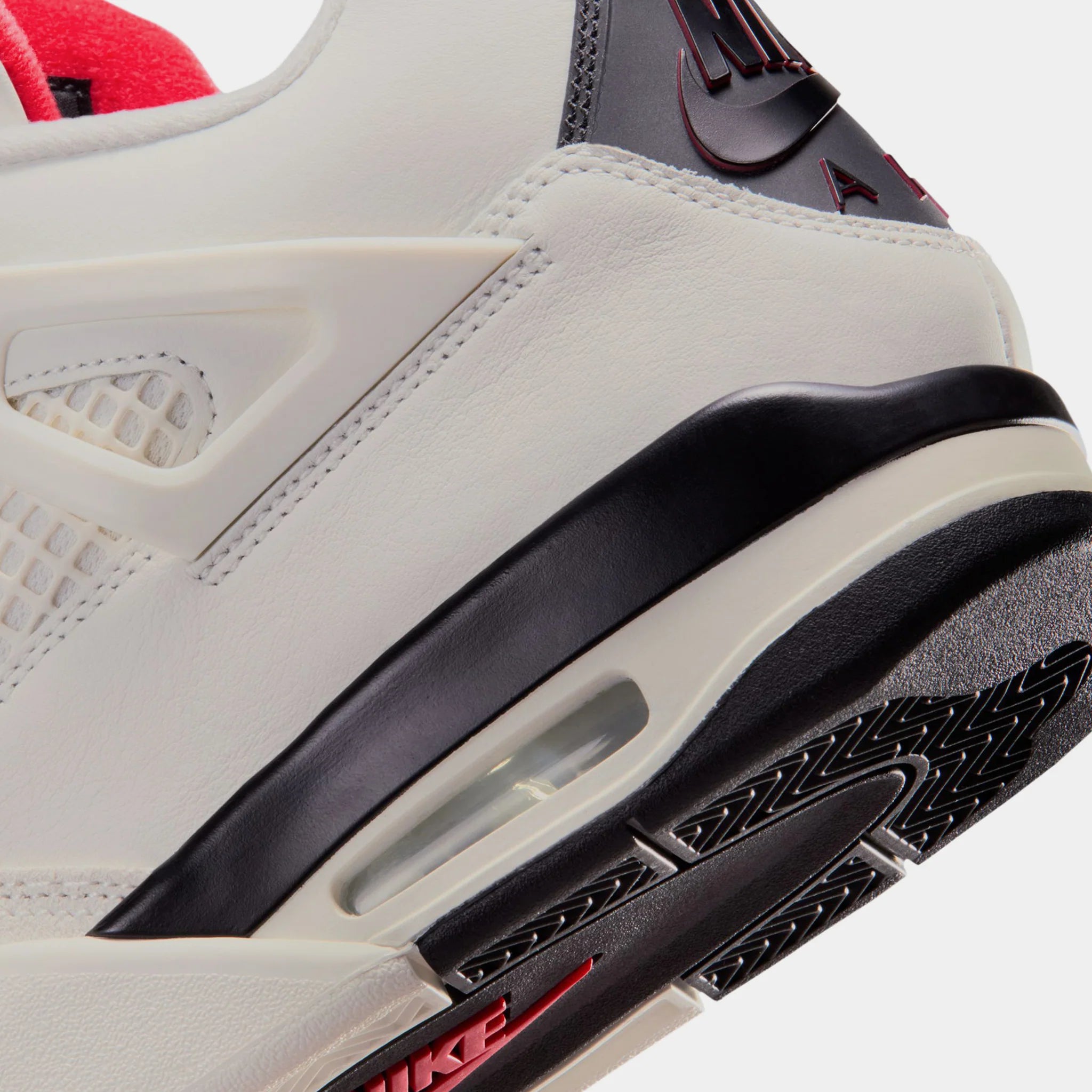 Air Jordan 4 Flight Club heel close-up showing sail leather upper, black midsole, visible Air cushioning unit, and red Nike branding on outsole