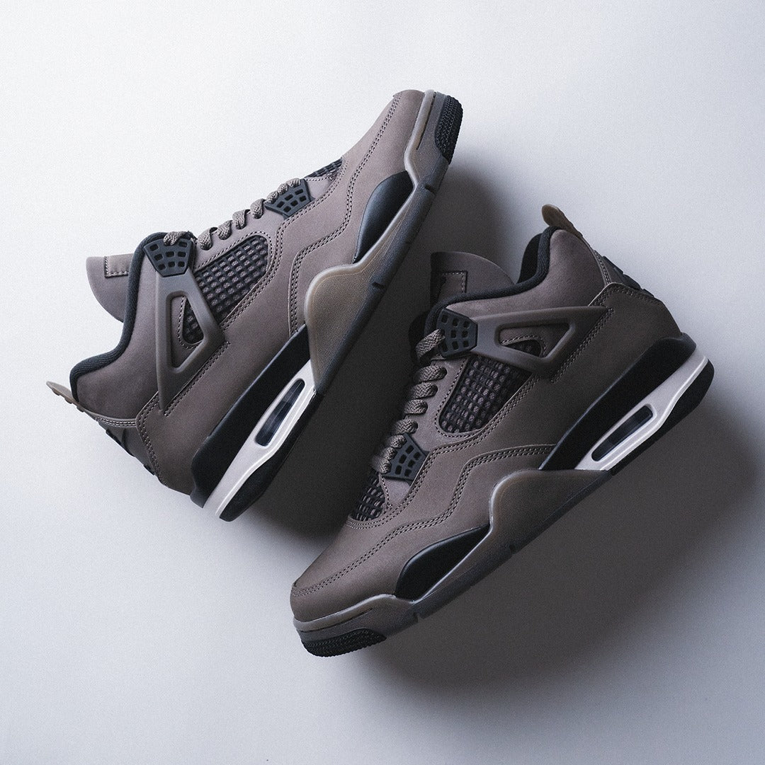 Jordan 4 Retro Cave Stone GS - overhead flat lay of both shoes stacked showing cave stone brown nubuck upper, black mesh netting and white Air-Sole unit