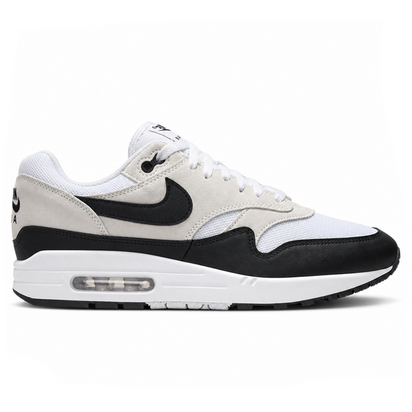 A side view of the Nike Air Max 1 Essential Summit White Black trainer, showing the white mesh upper, tan suede panels, black Nike Swoosh and visible Air midsole.