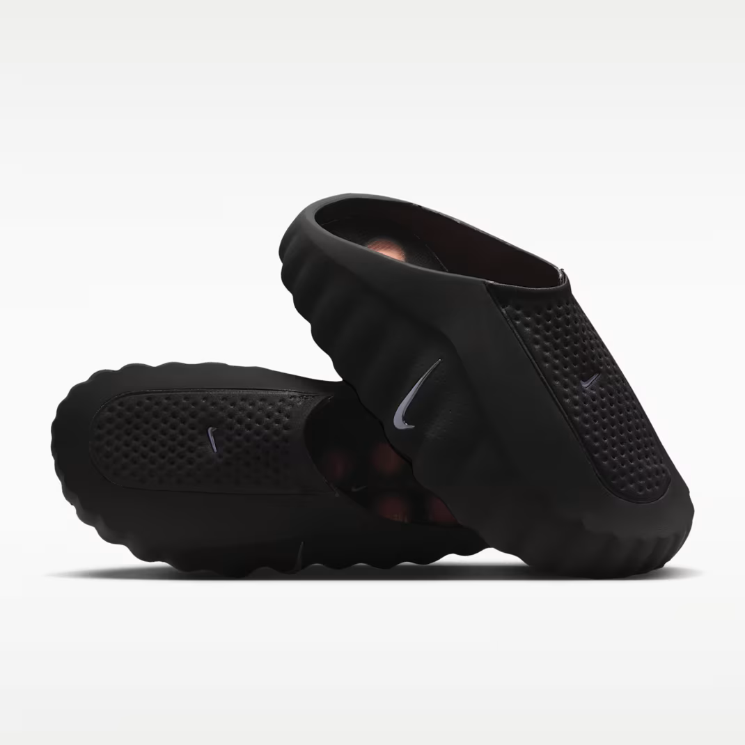Nike Mind 001 Black - stacked pair view showing medial side with perforated knitted upper, silver Nike Swoosh on both shoes, sculpted foam construction and orange inner lining visible