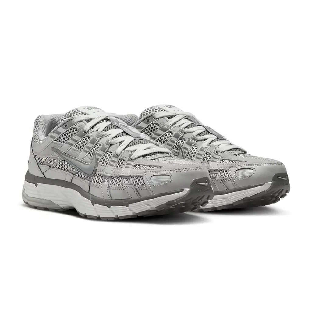 Nike P-6000 Light Iron Ore pair front three-quarter view on white background showing tonal grey colourway with perforated mesh, silver straps, and grey midsole accents