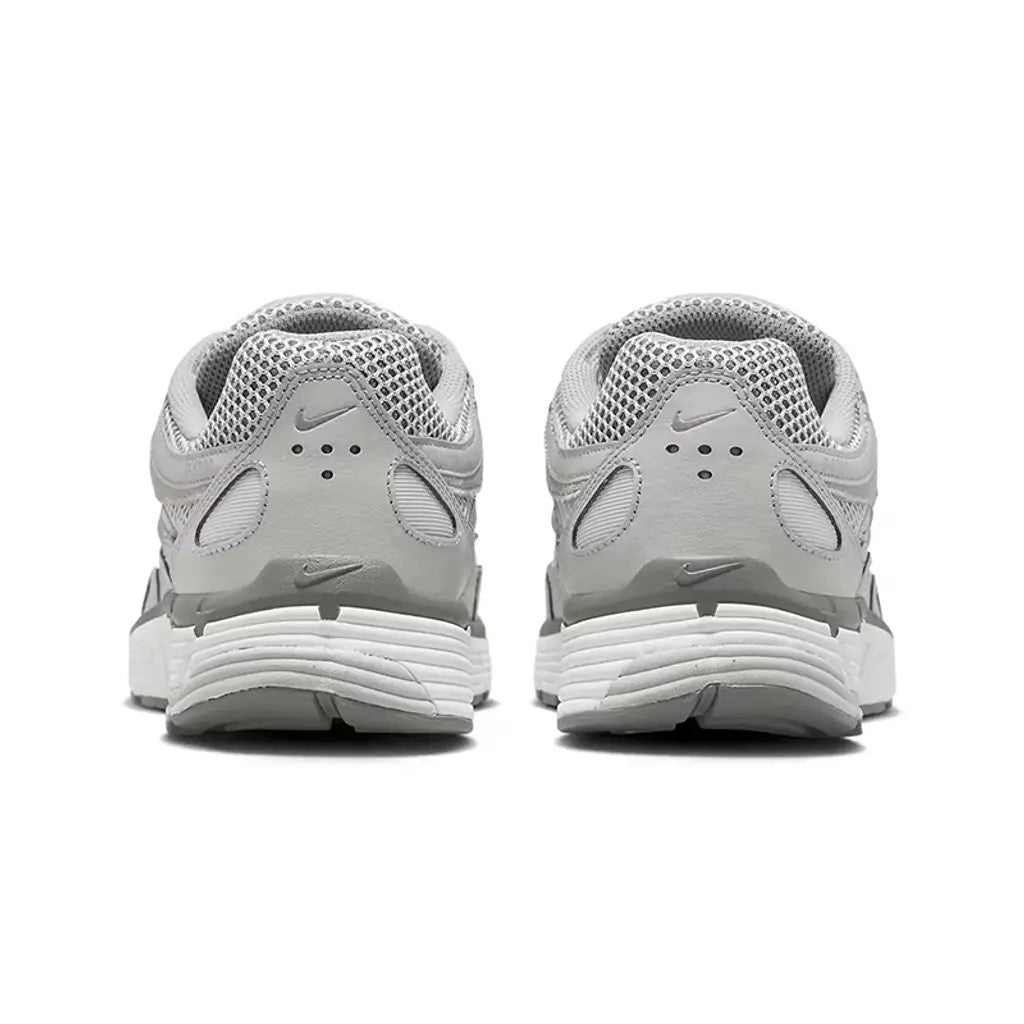 Nike P-6000 Light Iron Ore rear view of pair on white background showing grey leather heel counter, embroidered Nike Swoosh, mesh collar, and white layered midsole