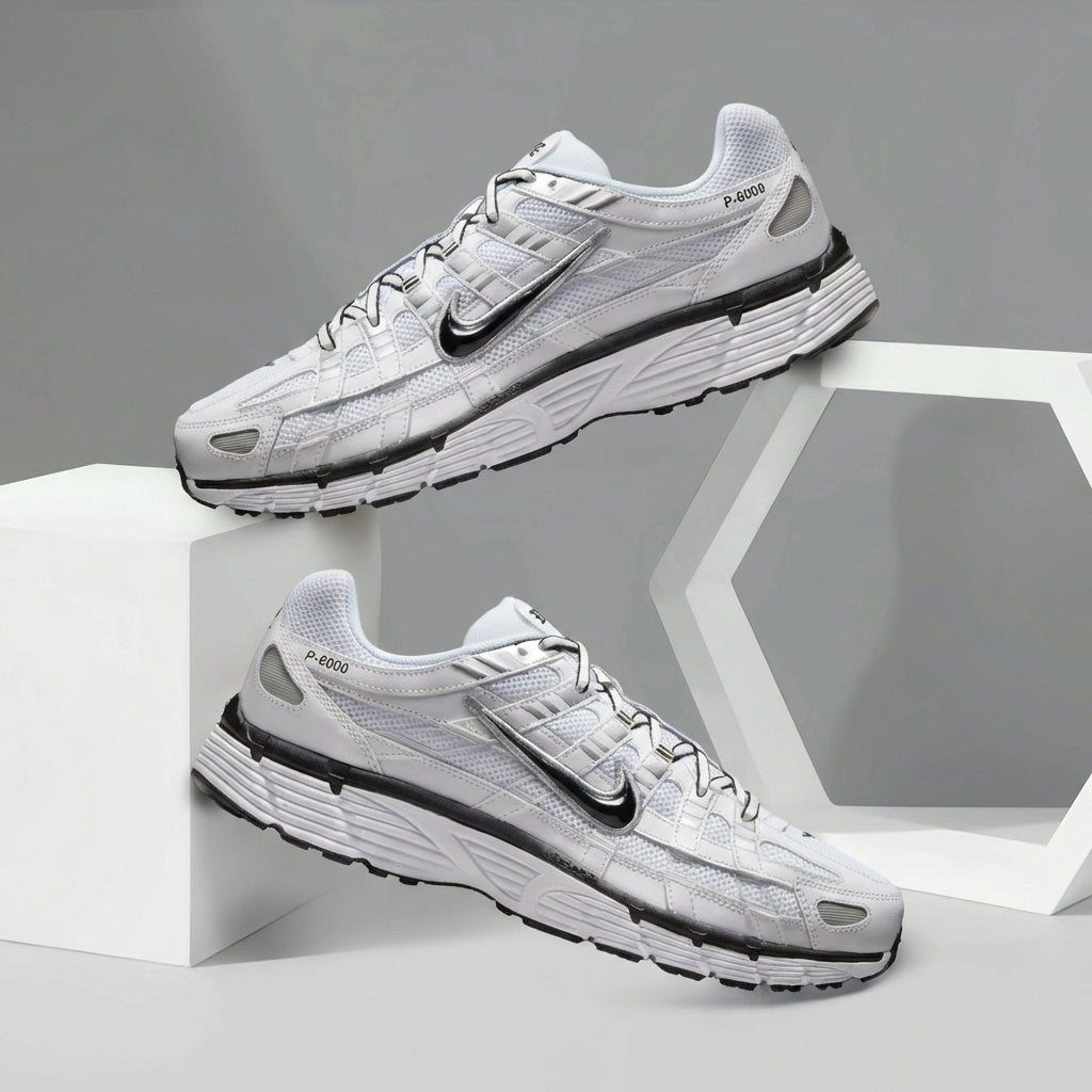 Nike P-6000 White Metallic Silver Black pair displayed on grey geometric background showing white mesh and chrome Swoosh