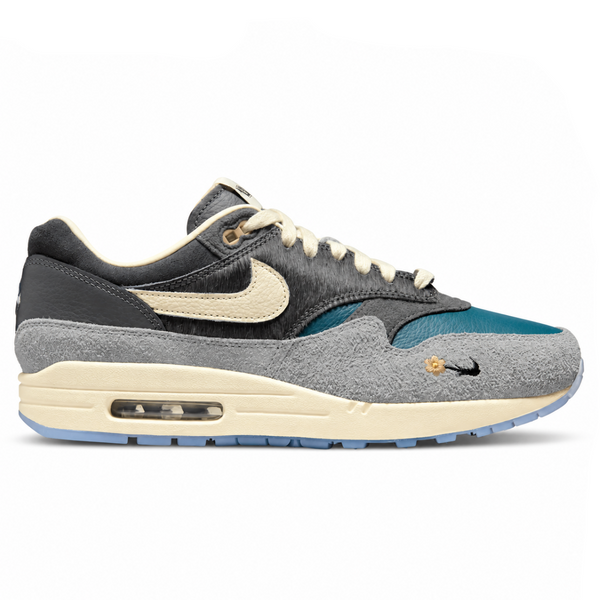 A side view of the Kasina x Nike Air Max 1 Wong-Ang Grey trainer, showing the premium teal leather upper, textured grey overlays, Nike Swoosh and layered Air Max 1 construction.