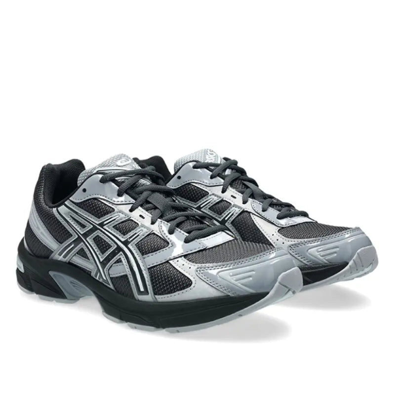 A pair of ASICS GEL-1130 Graphite Grey Gravel trainers featuring dark graphite mesh, glossy grey overlays, signature ASICS stripes and a cushioned GEL sole on a clean white background.