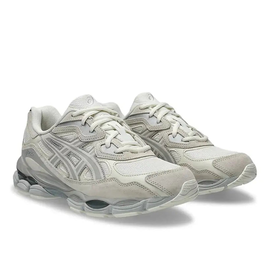 A pair of ASICS GEL-NYC Cream Grey trainers featuring cream mesh, tonal grey overlays, signature ASICS stripes and a sculpted cushioned sole on a clean white background.