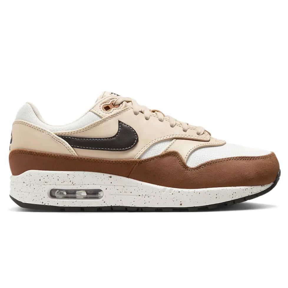A side view of the Nike Air Max 1 ’87 Velvet Brown women's trainer, showing the Sail mesh upper, deep brown suede mudguard, tan overlays and black Nike Swoosh.
