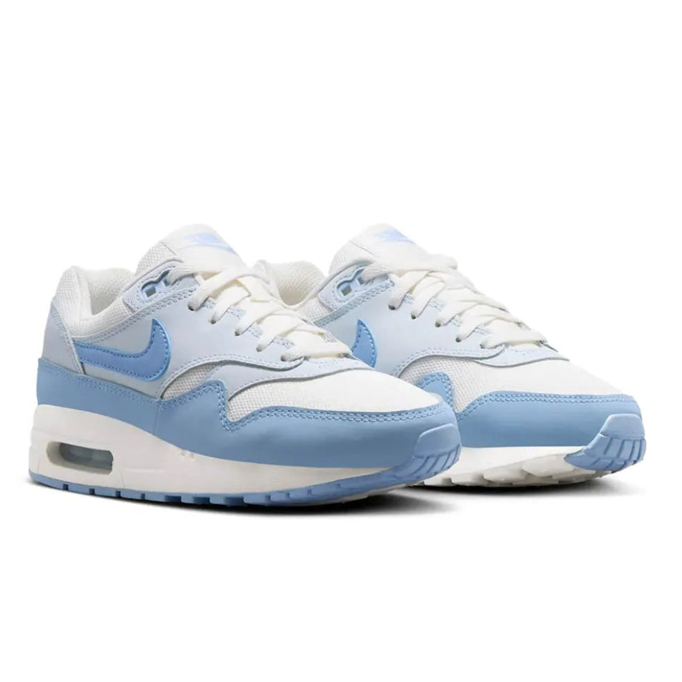 A pair of Nike Air Max 1 GS Sail Blue Tint trainers featuring white mesh, pastel blue leather overlays, signature Nike Swooshes and visible Air cushioning on a clean white background.
