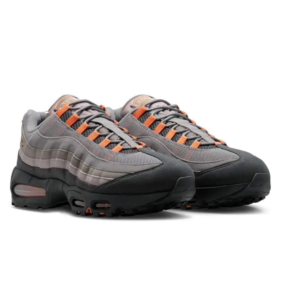 A pair of Nike Air Max 95 OG Big Bubble Bright Mandarin trainers featuring layered black and grey panels, vivid orange accents and visible Big Bubble Air cushioning on a clean white background.