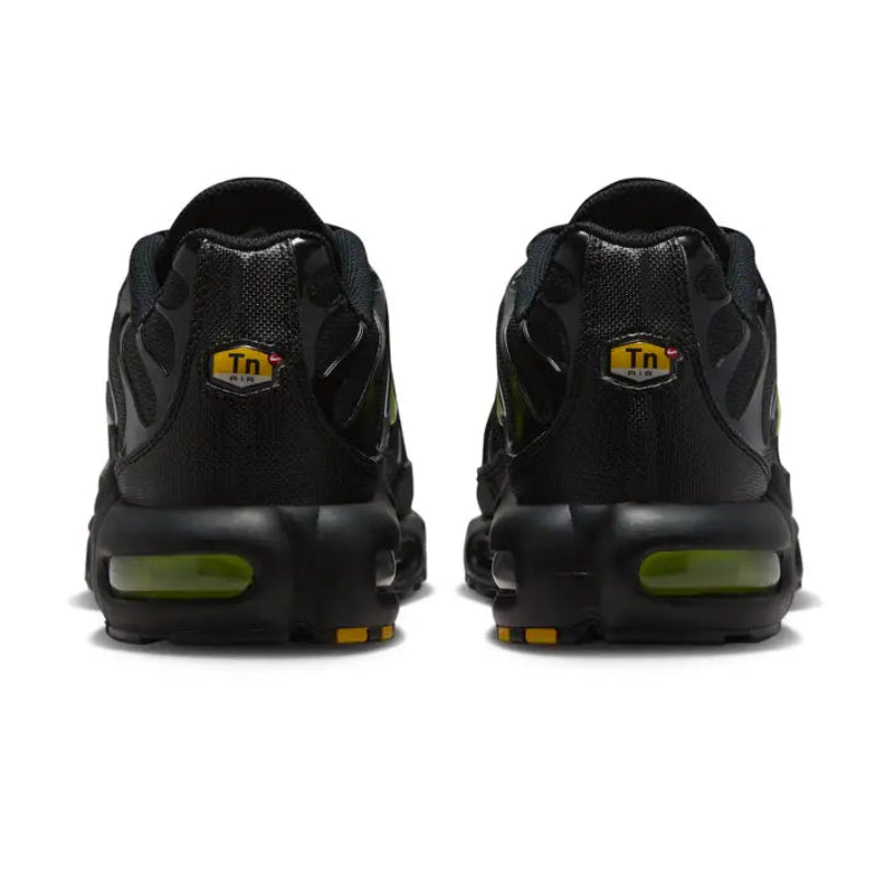 A rear view of the Nike Air Max Plus TN Black Volt Neon trainers, showing the structured black heel, Volt accents, TN branding and visible Air cushioning on a clean white background.
